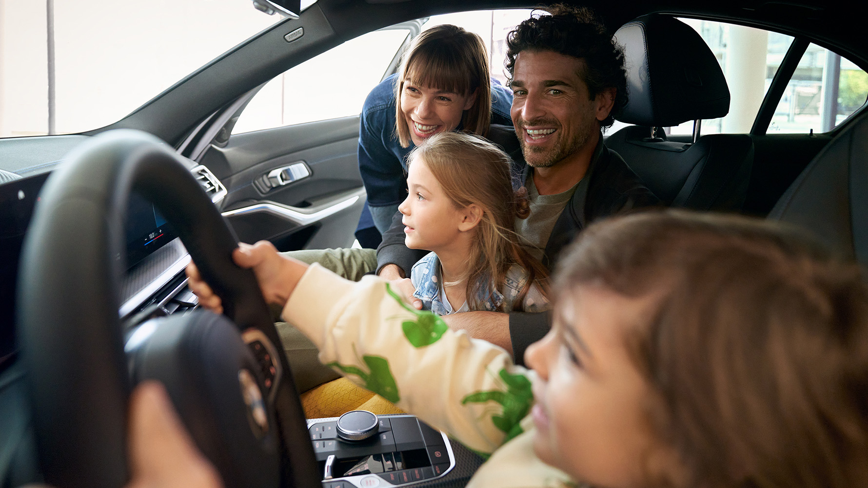 Das Bild zeigt eine Familie im Autohaus.